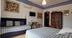 1 dormitorio con 2 camas y TV en la pared en B&B The Sunset, en Anacapri