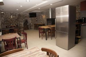 a restaurant with tables and a stainless steel refrigerator at Hostel-Albergue Monte Perdido in Torla-Ordesa