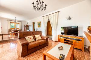 a living room with a couch and a tv at S'hort des Baladres Ibiza Villa in Santa Eularia des Riu