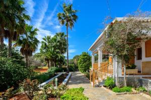 a house with a palm tree in the yard at S'hort des Baladres Ibiza Villa in Santa Eularia des Riu
