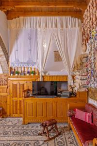 een woonkamer met een televisie en een bank bij Beautiful historic house in Koskinou