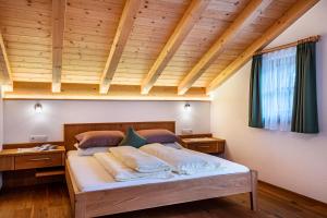 un grande letto in una camera con soffitto in legno di Feldererhof Apt Almenblick a Santa Maddalena in Casies