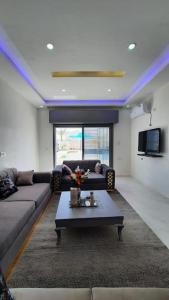 uma sala de estar com um sofá e uma mesa em Villa Line em Taguermess
