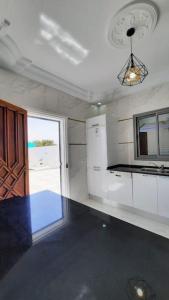 a kitchen with white cabinets and a window in it at Villa Line in Taguermess