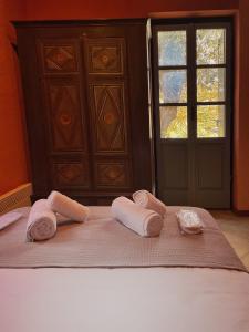 two towels are sitting on a bed with a window at The Blue Getaway - Next to Pithara Waterfalls in Andros