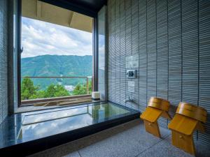 a bathroom with two benches and a window with a view at Yunoshimakan in Gero
