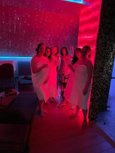 a group of women standing in a room with red lights at Apartament & Spa Rosa in Istebna