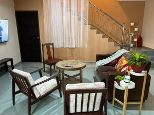 a living room with chairs and a bed and a table at Dino House in Taiping