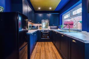 a kitchen with blue cabinets and a blue ceiling at Spacious and Modern 5 BR House in Manchester