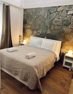 een slaapkamer met een groot bed en een stenen muur bij Stylish loft with fireplace, jacuzzi and gym in Agios Nikolaos