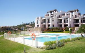 a swimming pool in front of a large building at Apartamento VISTA MAR in Casares