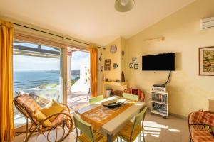 een woonkamer met een tafel en uitzicht op de oceaan bij Casa Ricale in Terra Mala