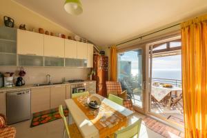 een keuken met een tafel en uitzicht op de oceaan bij Casa Ricale in Terra Mala