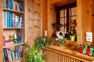 a room with a window with books and plants at Feldererhof Apt Hochstein in Santa Maddalena