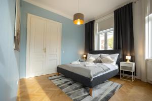 a bedroom with a bed with blue walls and windows at Turquoise inspired deluxe centrally located in Vienna