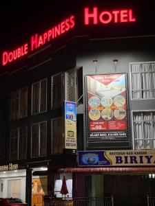 a hotel with signs on the side of a building at Double Happiness Hotel in Seri Manjung