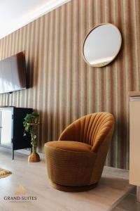brązowe krzesło w pokoju z lustrem w obiekcie Grand Suites Corvin w Budapeszcie