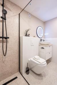 a bathroom with a shower with a toilet and a sink at KL35- Boutique Apartments, Best Location. By BQA in Budapest