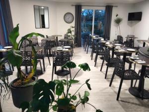a row of tables and chairs in a restaurant at Hotel Au Sans Souci in Chinon