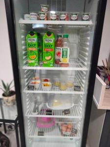 un réfrigérateur ouvert rempli de boissons et de nourriture dans l'établissement Hotel Au Sans Souci, à Chinon
