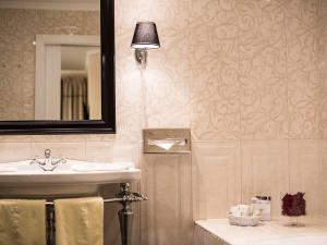 a bathroom with a sink and a mirror at Romantik SPA Hotel Seefischer in Döbriach
