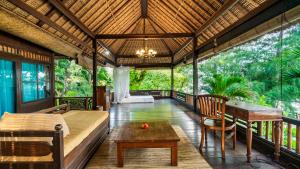 a room with a bed and a table on a balcony at Alam Gili Trawangan by Mahaputra in Gili Trawangan