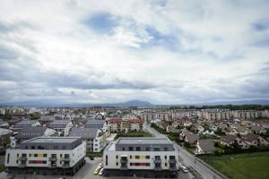 een luchtzicht op een stad met gebouwen en auto's bij Isaran Apartament with Panoramic City View in Braşov