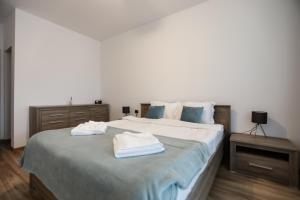 een slaapkamer met een groot bed en 2 handdoeken bij Isaran Apartament with Panoramic City View in Braşov
