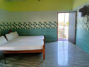 - une chambre avec un lit dans une pièce aux murs verts dans l'établissement Blue Leaf Residency, à Rameswaram