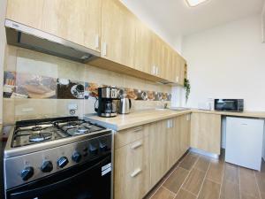 a kitchen with wooden cabinets and a stove top oven at New City Studios with Balcony in Bucharest