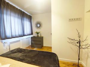 een slaapkamer met een bed, een ladekast en een raam bij Apartment Dada in Zagreb