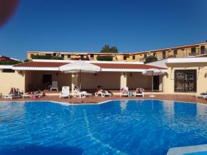 a pool at a hotel with chairs and umbrellas at Marasusa in Parghelia +33 photos