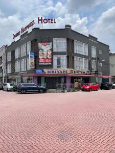 a hotel with cars parked in front of it at Double Happiness Hotel in Seri Manjung