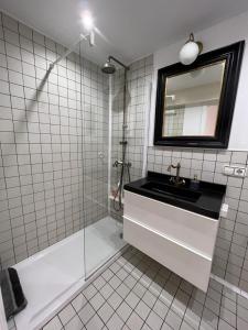 y baño de azulejos blancos con lavabo y ducha. en Ruzafa Beach, en Benidorm