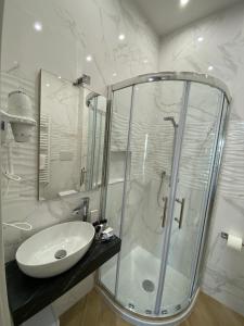 a white bathroom with a sink and a shower at ESPERIA B&B in Oliveri