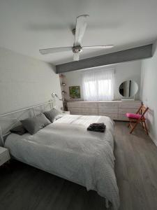 a bedroom with a large bed and a pink chair at Ruzafa Beach in Benidorm