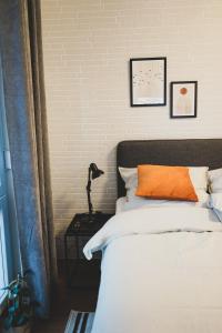1 dormitorio con 1 cama con almohada naranja en Modernes Wohlfühl-Apartment an den Kaiserthermen en Tréveris