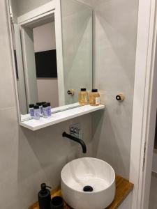 La salle de bains est pourvue d'un lavabo blanc et d'un miroir. dans l'établissement Modern studio apartment B, à Athènes