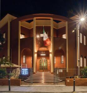 um edifício com uma bandeira na frente à noite em Hotel Villa Alberti Portofino Land em Santa Margherita Ligure