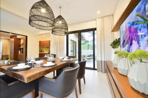 une salle à manger avec une grande table et des chaises en bois dans l'établissement The Apartments at El Nido, à El Nido