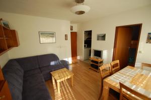ein Wohnzimmer mit einem Sofa und einem Tisch in der Unterkunft Familienappartement Talblick include Jokercard - only summer in Saalbach-Hinterglemm