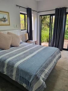 a bedroom with a large bed and sliding glass doors at 12onParkesLane in Knysna