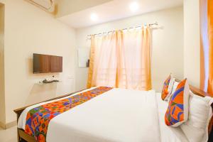 um quarto com uma cama e uma televisão em FabHotel Corner Courtyard em Kondapur