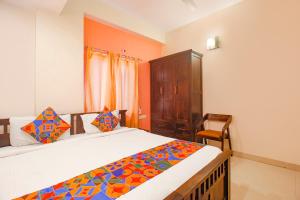 une chambre avec un lit et une armoire en bois dans l'établissement Via Corner Courtyard - Nr Botanical Garden, Kondapur, à Kondapur