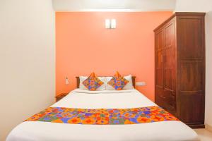 une chambre avec un grand lit aux murs orange dans l'établissement Via Corner Courtyard - Nr Botanical Garden, Kondapur, à Kondapur 23 autres photos