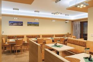 a restaurant with tables and chairs in a room at Apartmány Řezáč in Rokytnice nad Jizerou