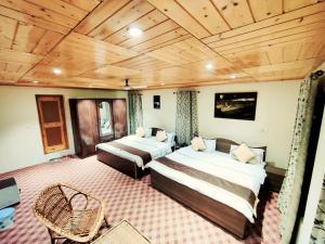 a bedroom with two beds and a wooden ceiling at Sheesha Residency in Srinagar