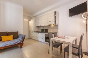 een woonkamer met een tafel en een bank bij San Donato Fiere Essential Apartment w/parking in Bologna