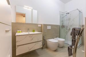 een badkamer met een toilet, een wastafel en een douche bij San Donato Fiere Essential Apartment w/parking in Bologna