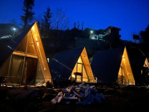 a group of three triangular buildings at night at Sunshine Cafe & Cottage Riverside in Shoja